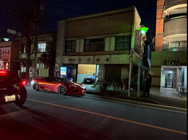 夜の店舗前に停まるスポーツカー